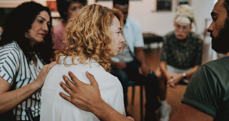 A woman sits in a grief counsel group.