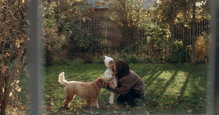 A mother plays with her child and doh in the backyard.
