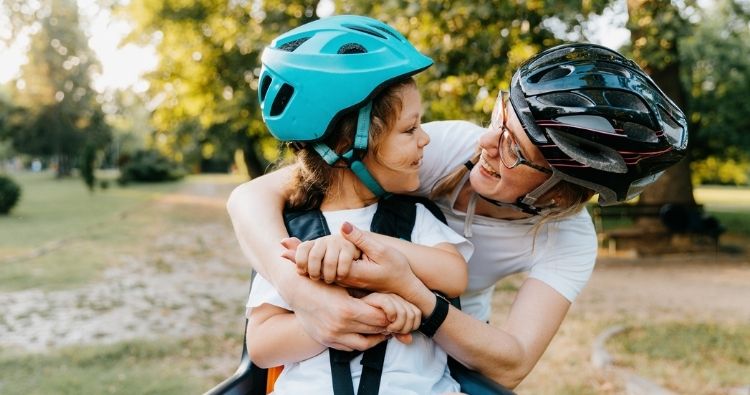 Parent and child wearing bike helmets outdoors