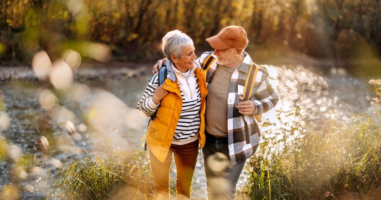 An older white retirement-aged women smiles while swinging.